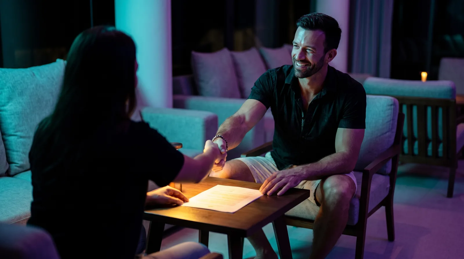 Matt Clark casually shaking hands across a table with a client, the agreement already glowing between them