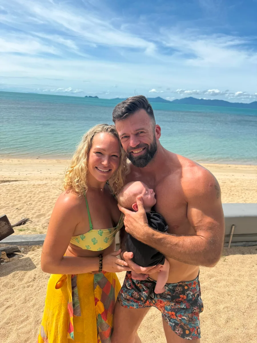 Matt and Kelly Clark on the beach in Thailand with their baby boy